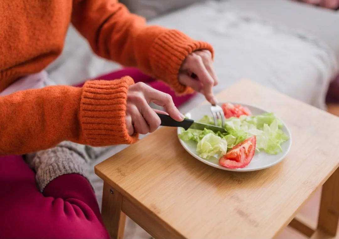 Ensaladera con alimentos frescos y un tenedor sobre una mesa, simbolizando la relación con la comida y los trastornos de la conducta alimentaria